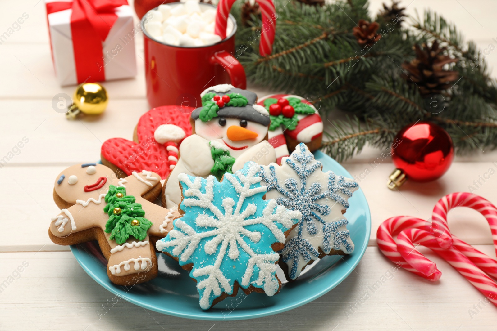 Photo of Delicious homemade Christmas cookies and festive decor on white wooden table