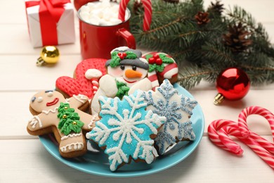 Photo of Delicious homemade Christmas cookies and festive decor on white wooden table