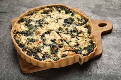Delicious homemade spinach quiche on gray table