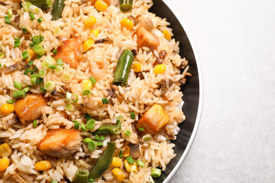 Photo of Delicious rice pilaf with chicken and vegetables on light grey table, closeup