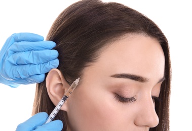 Photo of Young woman with hair loss problem receiving injection on white background