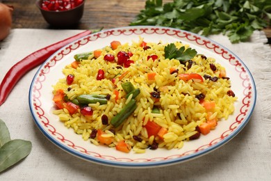 Photo of Tasty rice pilaf with vegetables on table