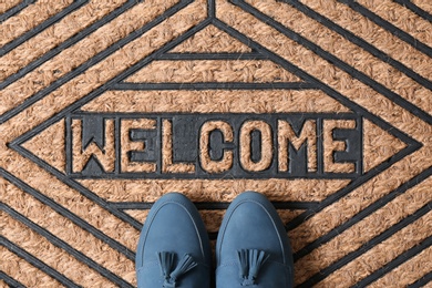 Photo of Blue female shoes on brown welcome doormat, top view