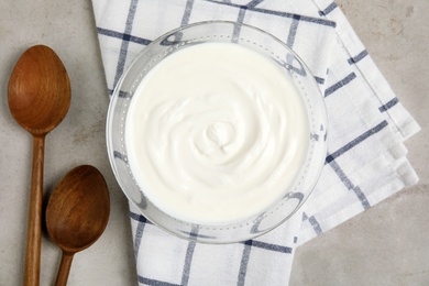 Glass bowl with creamy yogurt served on table, top view