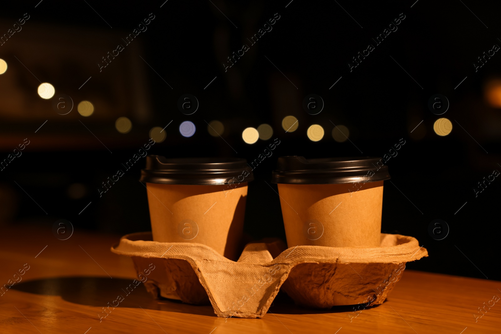 Photo of Paper coffee cups on wooden table in cafe