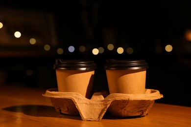 Photo of Paper coffee cups on wooden table in cafe