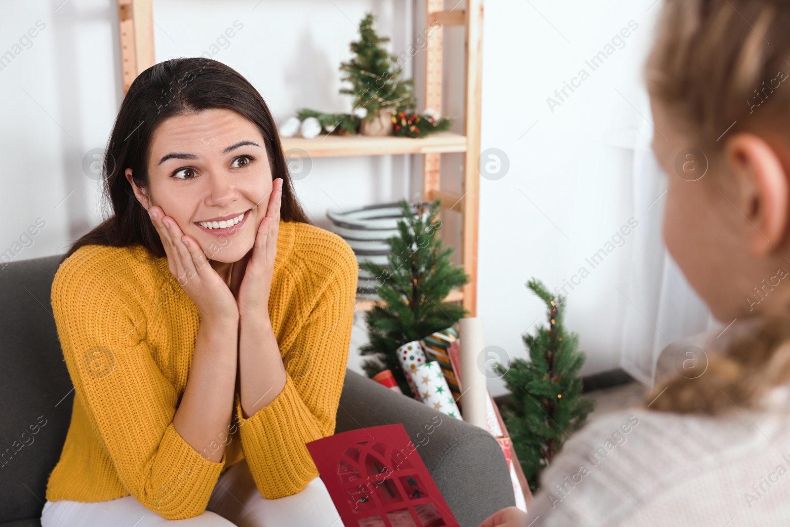 Photo of Happy woman receiving greeting card from her daughter at home