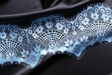 Photo of Light blue lace on black fabric, top view