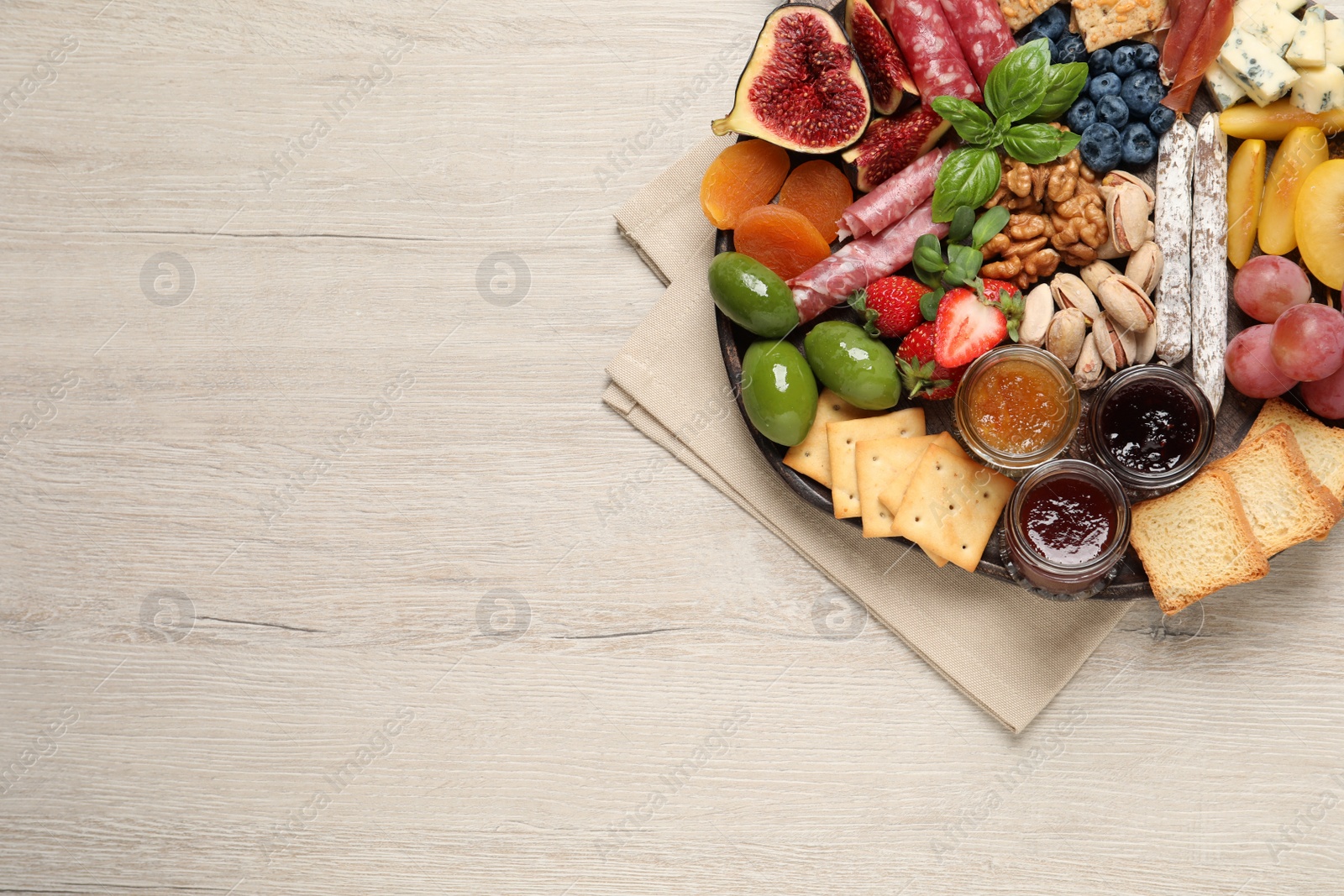 Photo of Different tasty appetizers on wooden table, top view. Space for text
