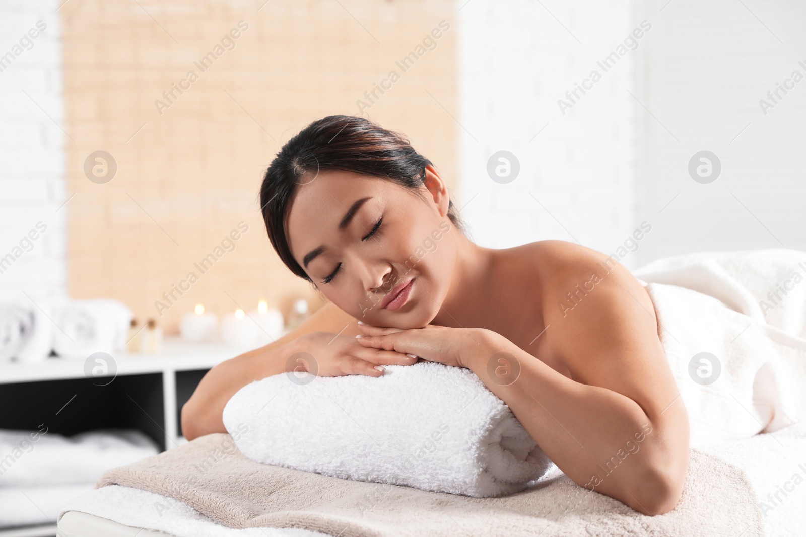 Photo of Beautiful Asian woman lying on massage table in spa salon