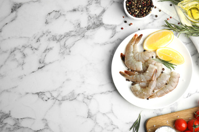 Photo of Flat lay composition with fresh raw shrimps on marble table. Space for text