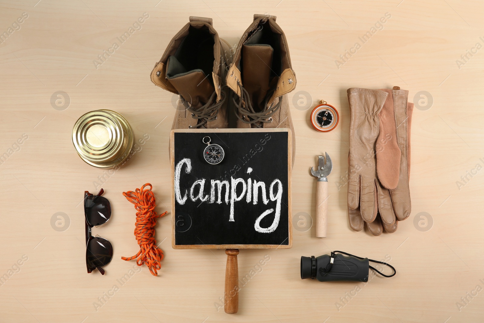 Photo of Flat lay composition with camping equipment on wooden background