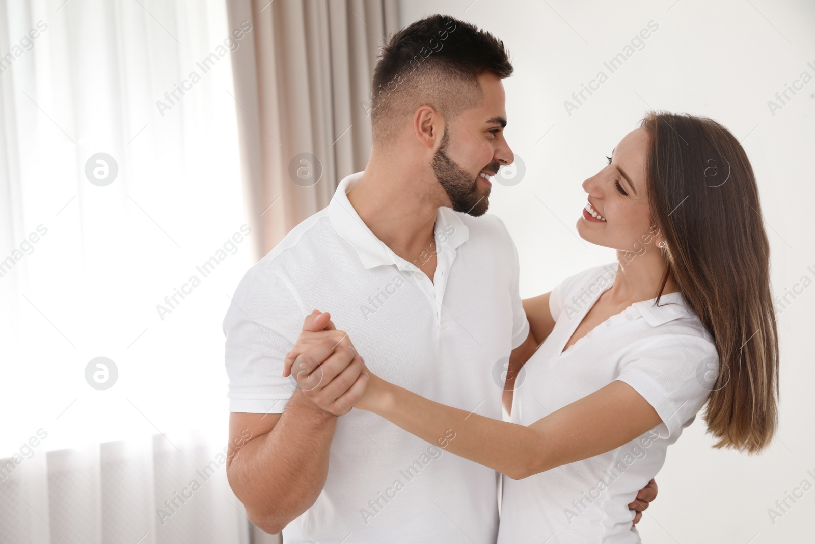 Photo of Lovely young couple dancing together at home