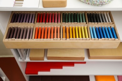 Photo of Wooden box with color tablets and other montessori toys on shelves