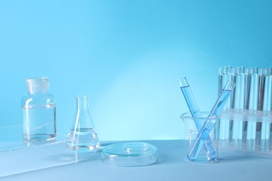 Photo of Laboratory analysis. Different glassware on table against light blue background