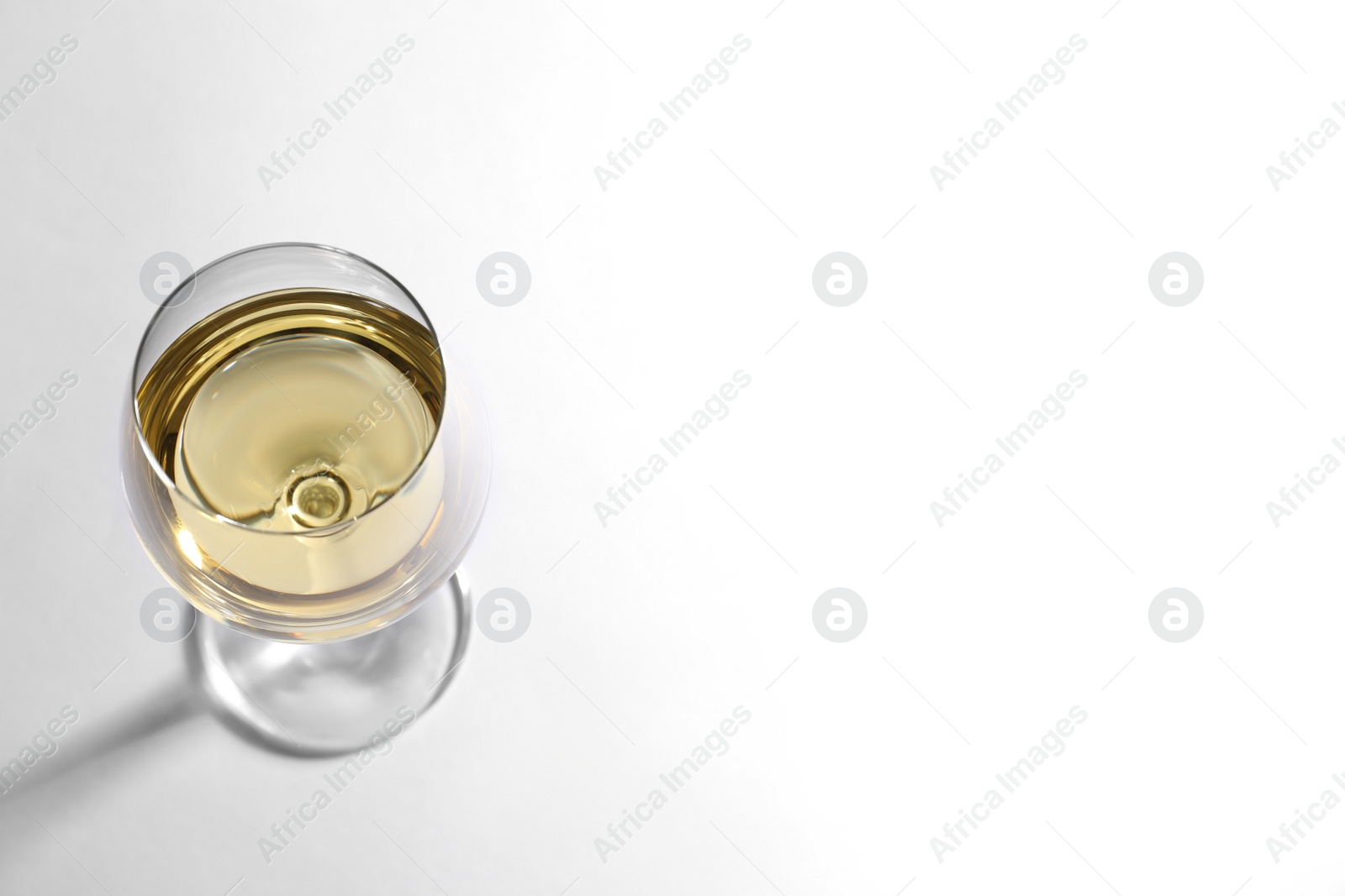 Photo of Glass of delicious wine on white background, above view