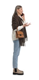 Photo of Senior woman with bag talking on smartphone against white background