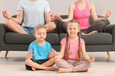 Photo of Happy family meditating together at home, closeup. Harmony and zen