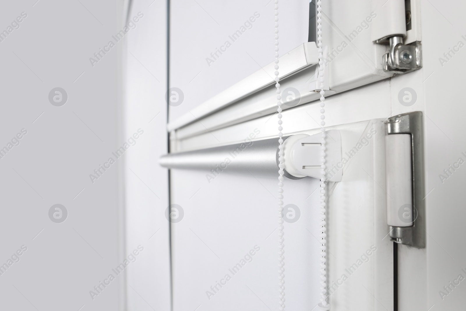 Photo of Window with white roller blinds indoors, closeup