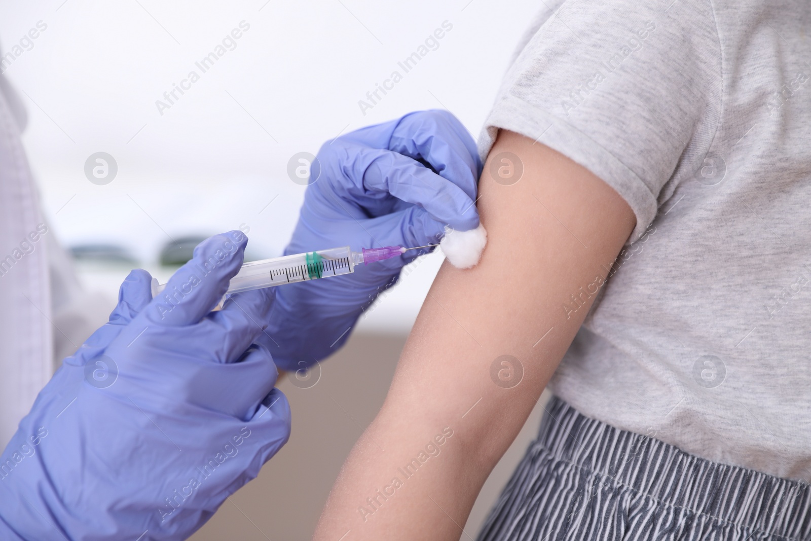 Photo of Little girl receiving chickenpox vaccination in clinic, closeup. Varicella virus prevention