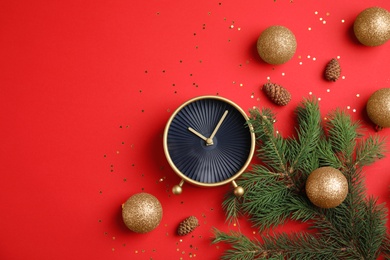 Photo of Flat lay composition with alarm clock, fir branches and beautiful decorations on color background. Christmas countdown