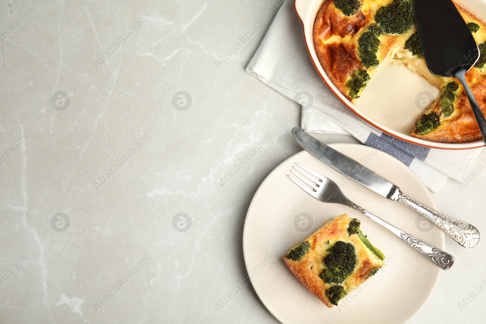 Photo of Tasty broccoli casserole served on grey marble table, flat lay. Space for text