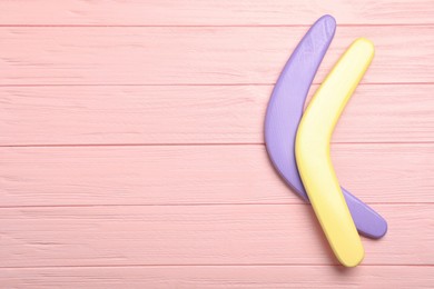 Photo of Boomerangs on pink wooden background, flat lay. Space for text