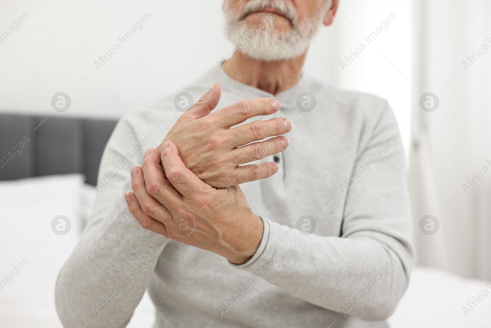 Photo of Arthritis symptoms. Man suffering from pain in wrist at home, closeup