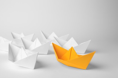 Photo of Orange paper boat among others on white background. Leadership concept
