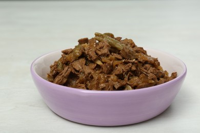 Photo of Wet pet food in feeding bowl on white table