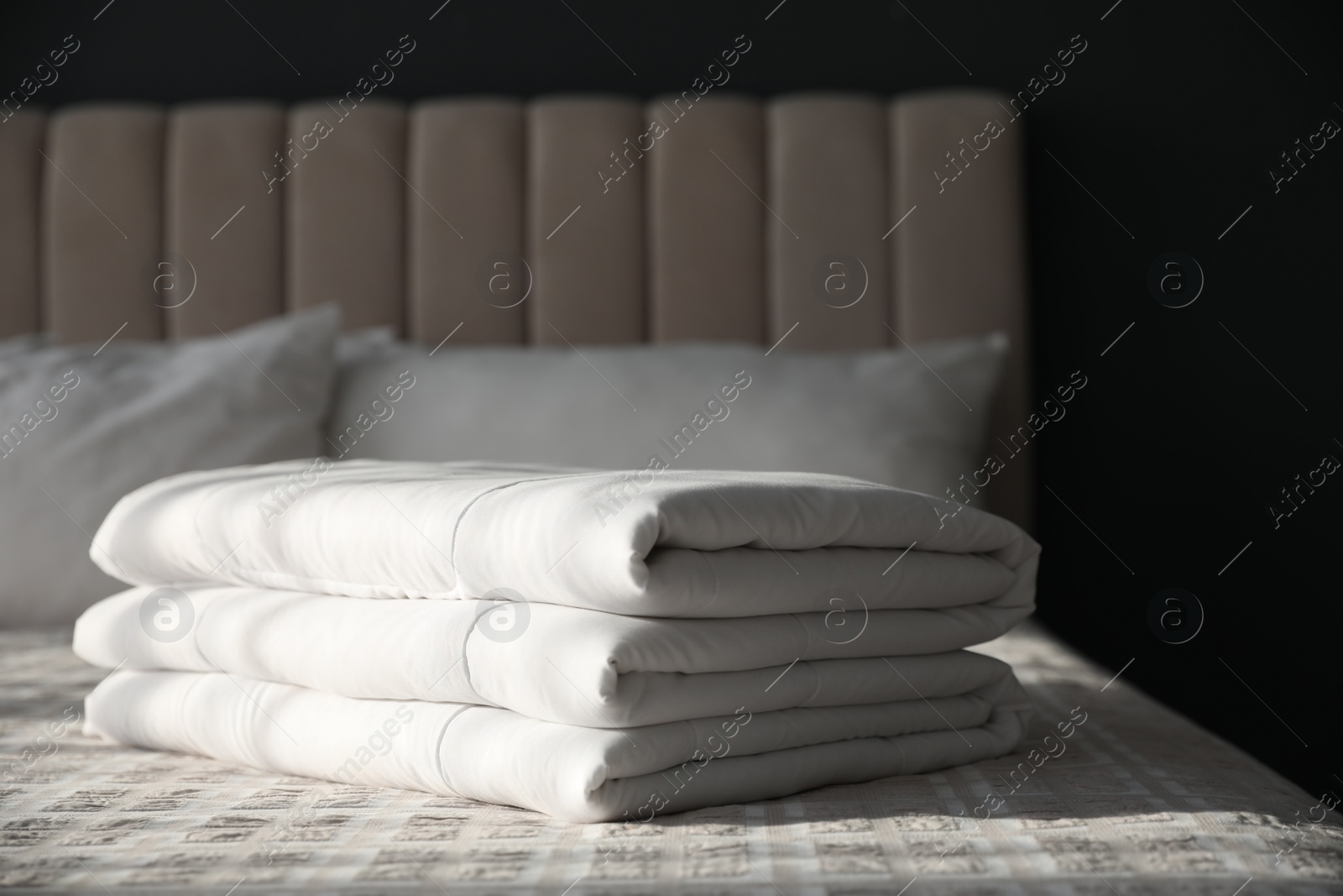 Photo of Folded clean blanket on bed in room