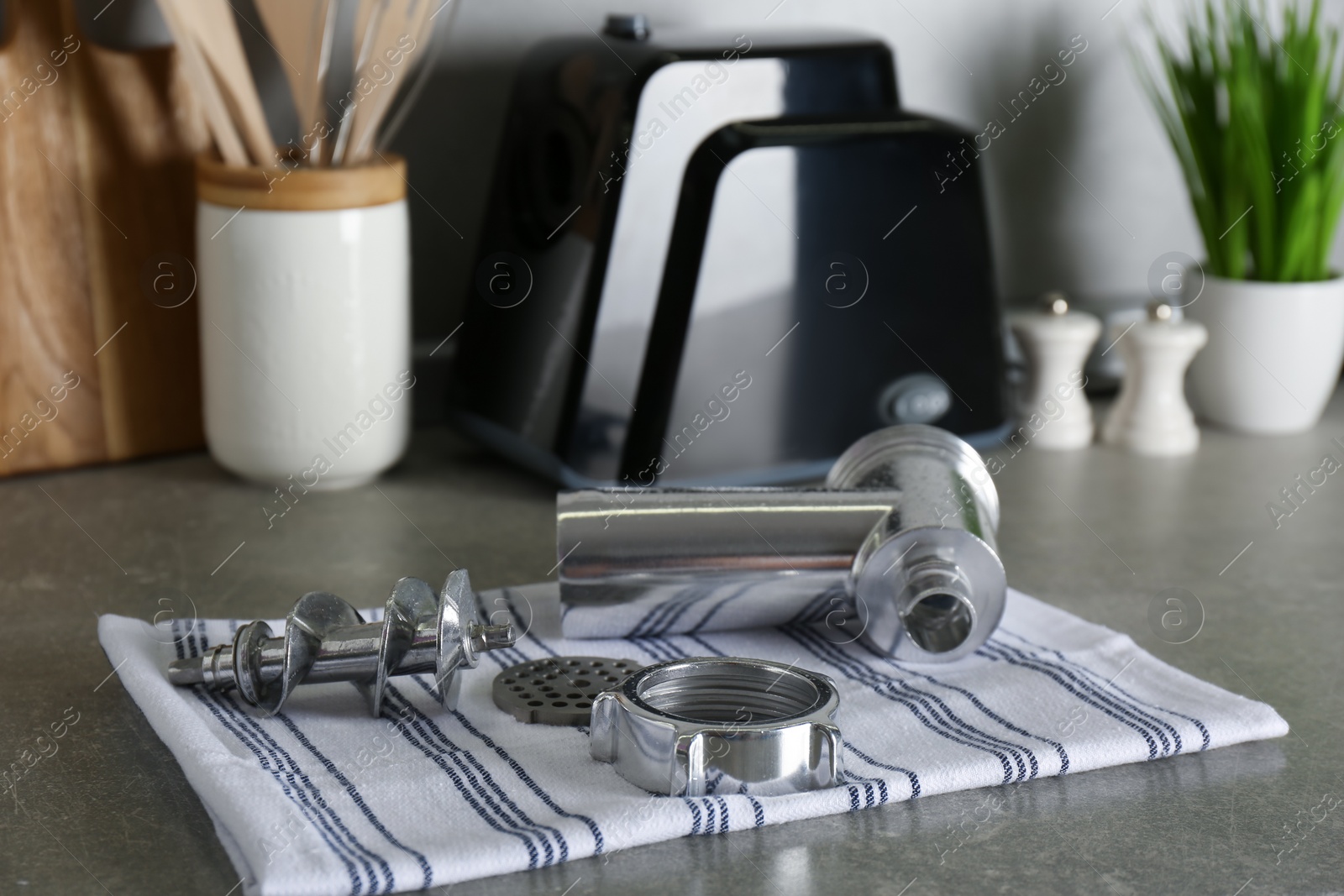 Photo of Clean parts of electric meat grinder on grey table indoors