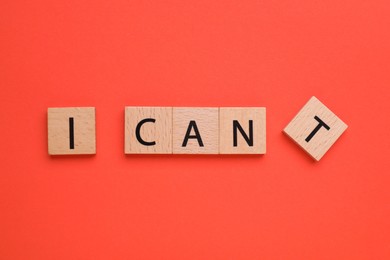 Motivation concept. Changing phrase from I Can't into I Can by removing square with letter T on red background, top view