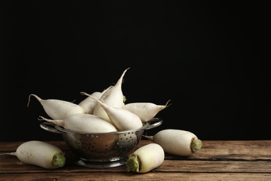 Photo of White turnips on wooden table. Space for text