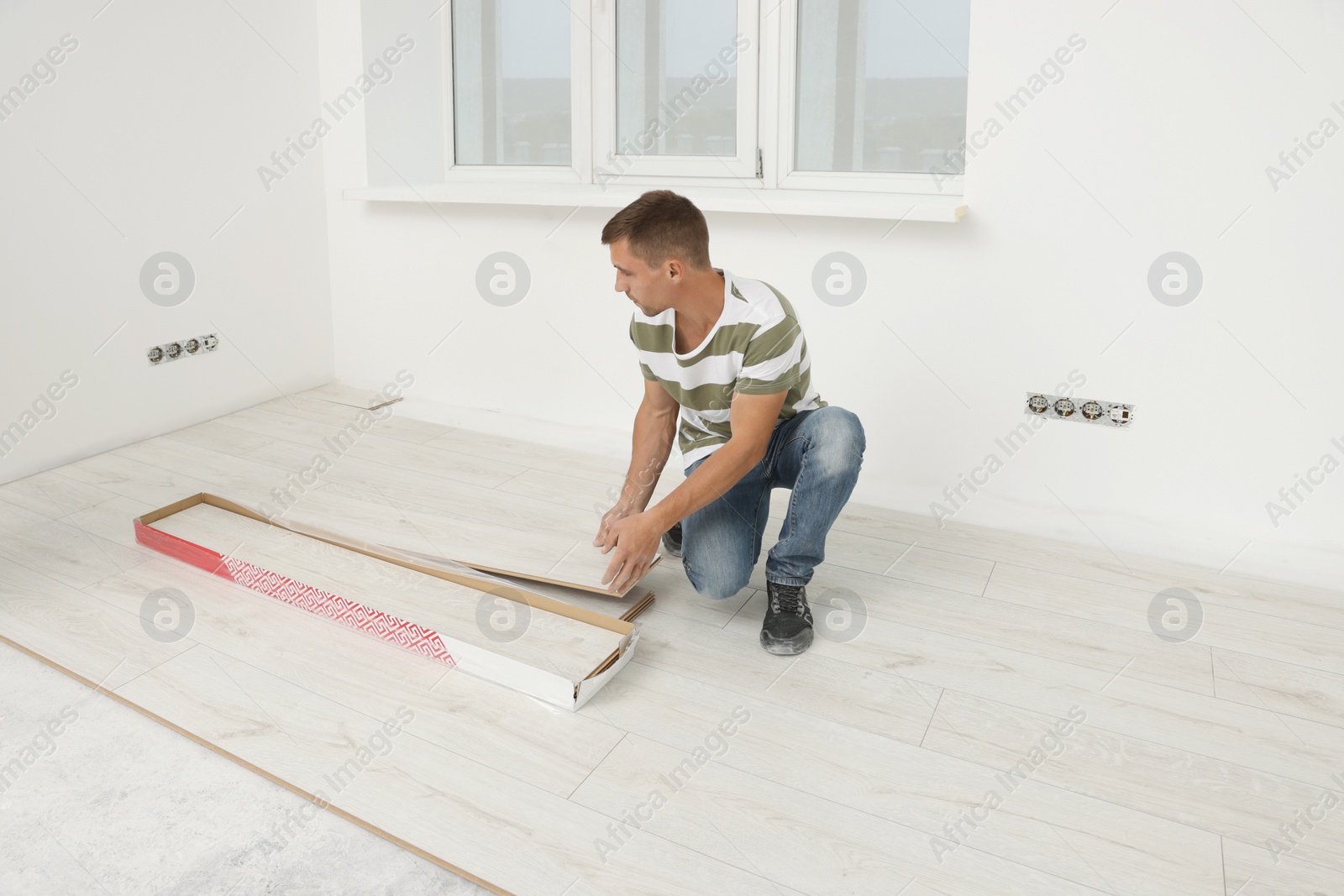 Photo of Professional worker installing new laminate flooring indoors