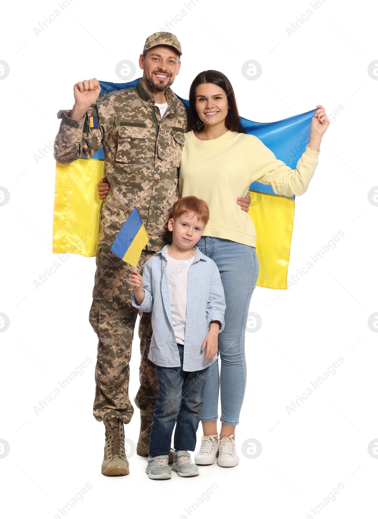 Photo of Ukrainian defender in military uniform and his family with flags on white background