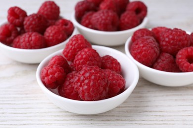 Tasty ripe raspberries on white wooden table, closeup