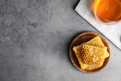 Photo of Fresh delicious honeycombs on grey table, top view. Space for text