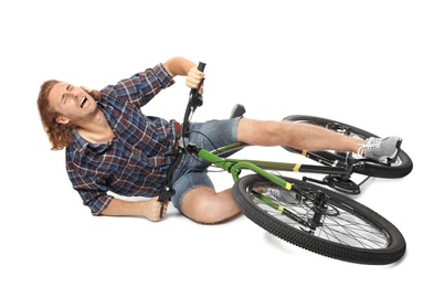 Young man falling off his bicycle on white background