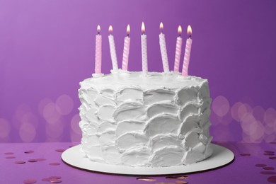 Photo of Delicious cake with cream and burning candles on purple background