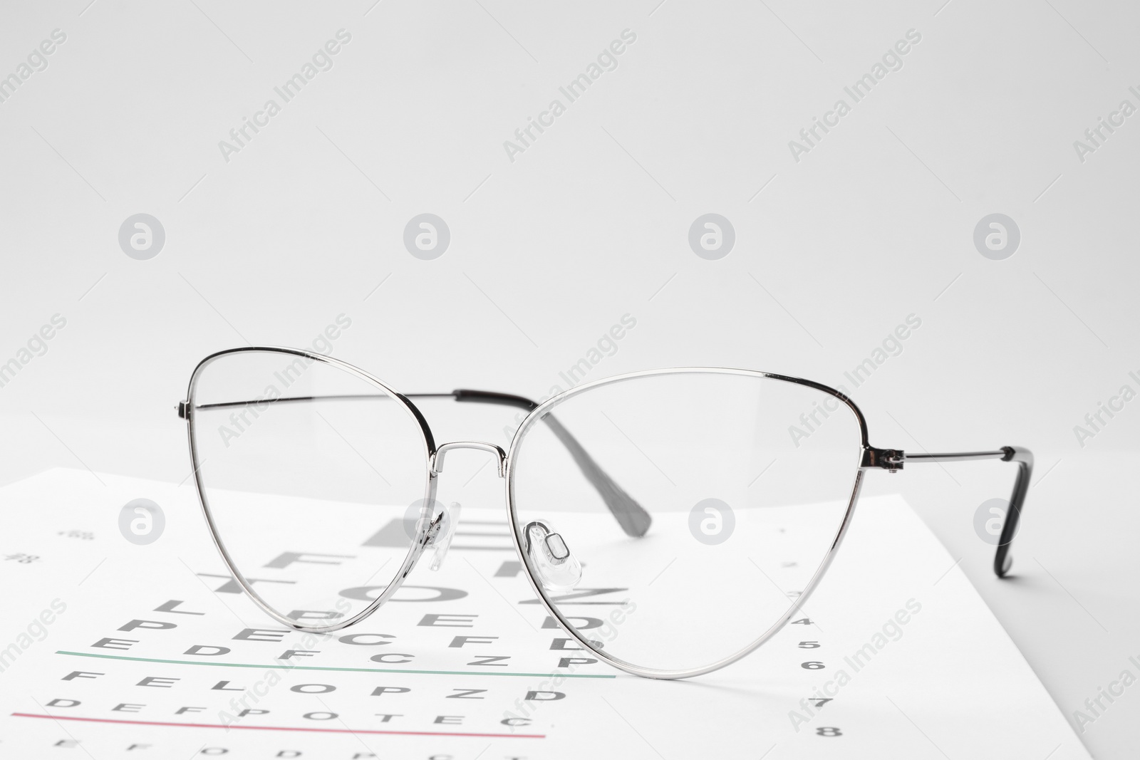 Photo of Glasses and vision test chart isolated on white