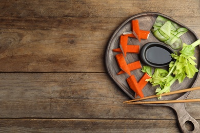 Fresh crab sticks with lettuce and soy sauce  on wooden table, top view. Space for text