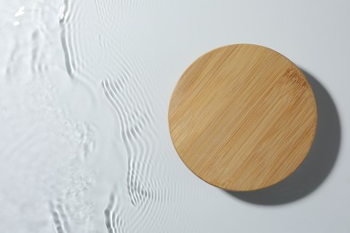 Photo of Presentation of product. Wooden podium in water on white background, top view. Space for text