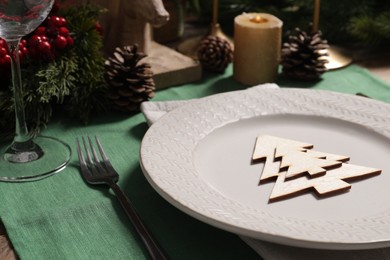 Festive place setting with beautiful dishware, cutlery and decor for Christmas dinner on wooden table, closeup