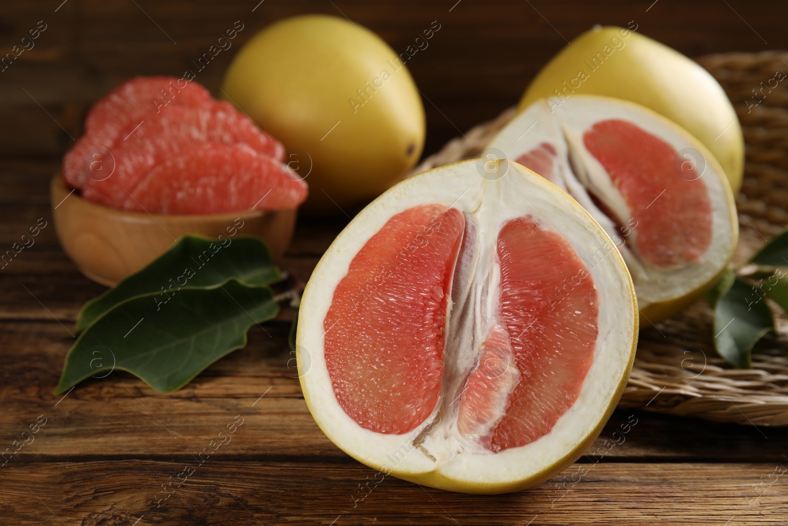 Photo of Fresh cut pomelo fruits on wooden table, closeup