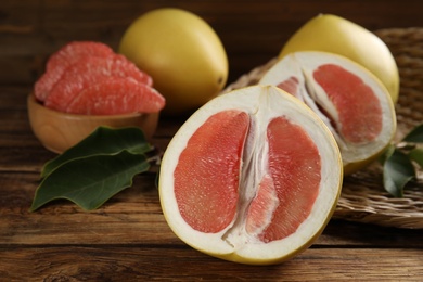 Photo of Fresh cut pomelo fruits on wooden table, closeup