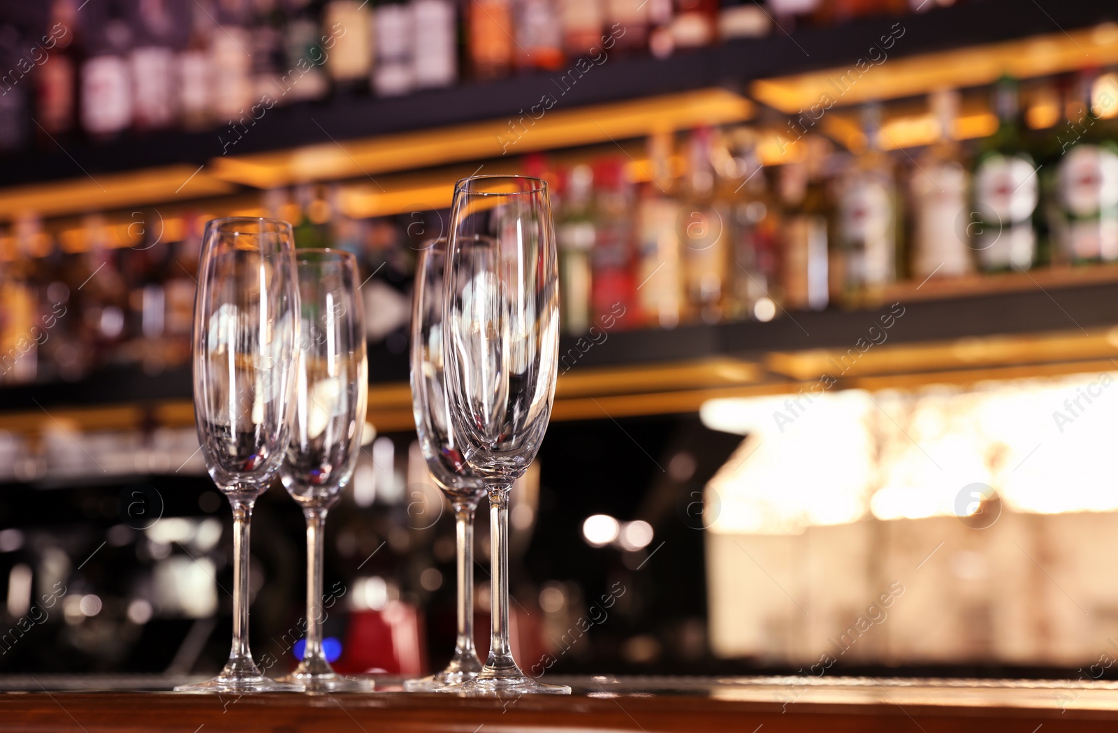 Photo of Empty clean champagne glasses on counter in bar. Space for text