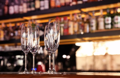 Photo of Empty clean champagne glasses on counter in bar. Space for text