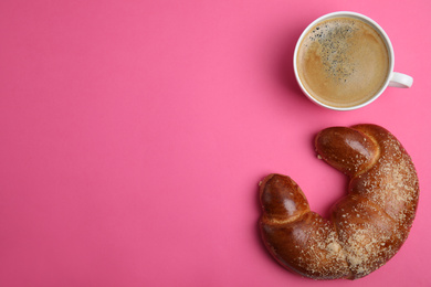 Photo of Delicious coffee and pastry on pink background, flat lay. Space for text