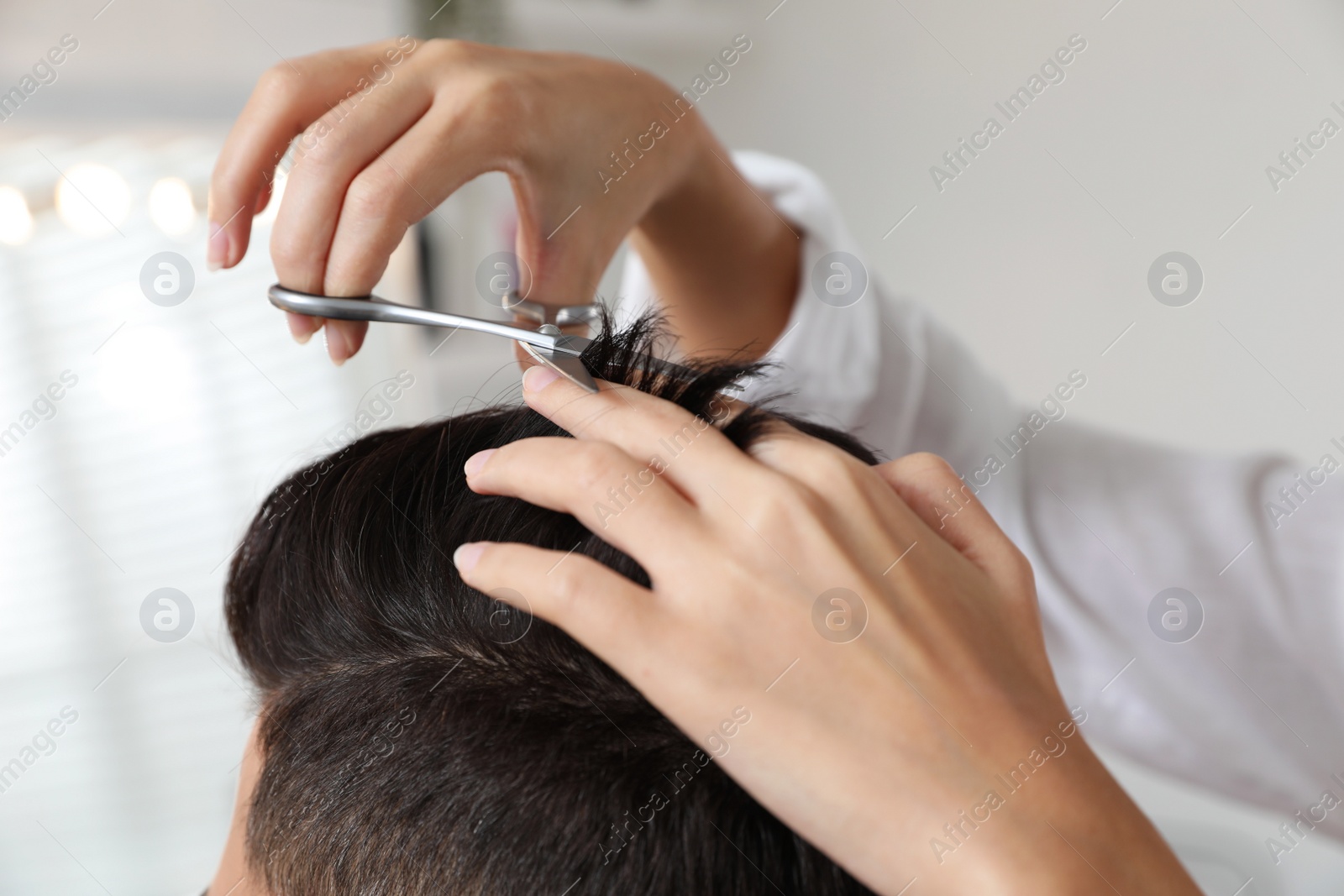 Photo of Professional stylist working with client in salon, closeup. Hairdressing services during Coronavirus quarantine